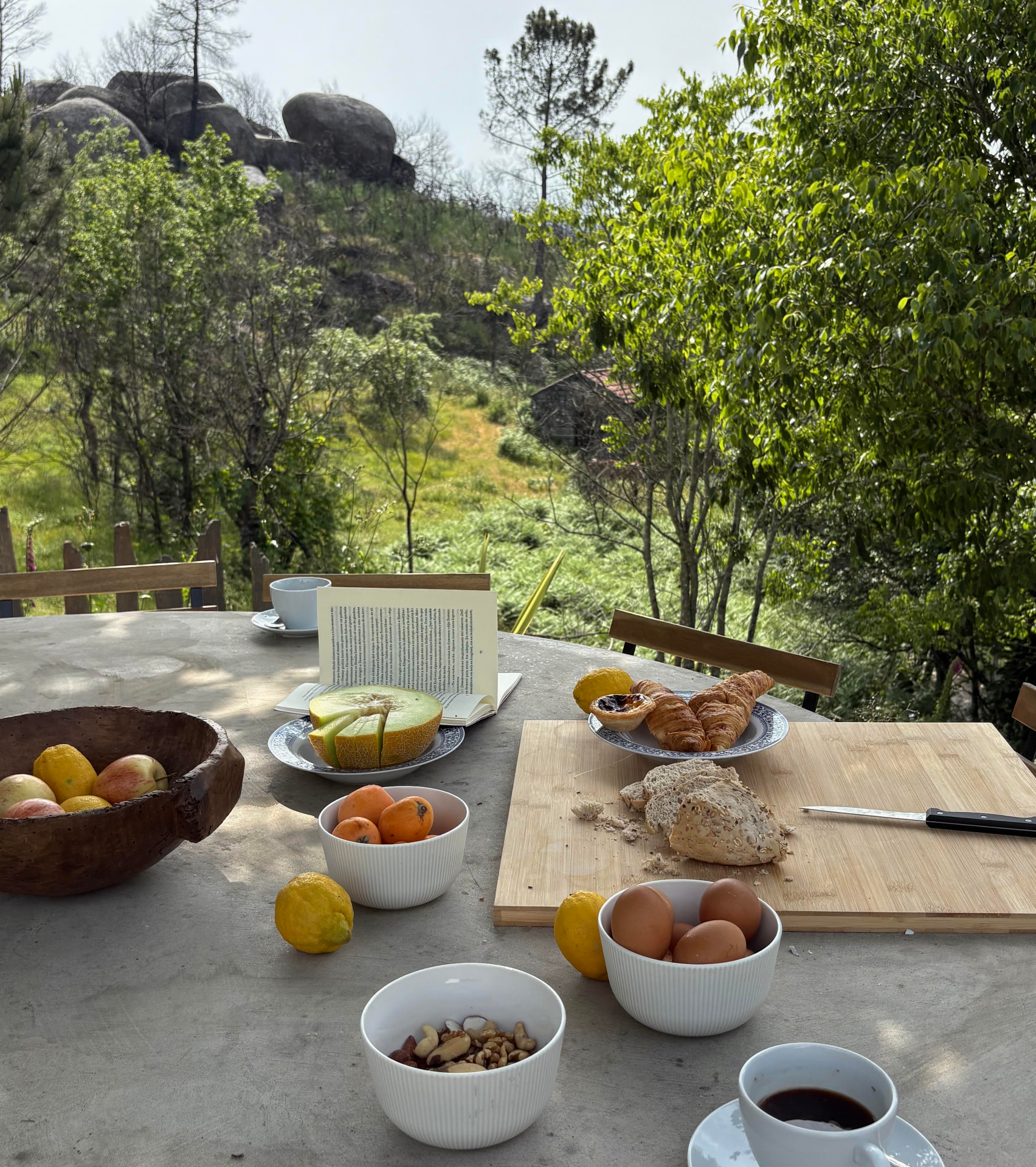 Breakfast spread on the outdoor concrete dining table with valley views
