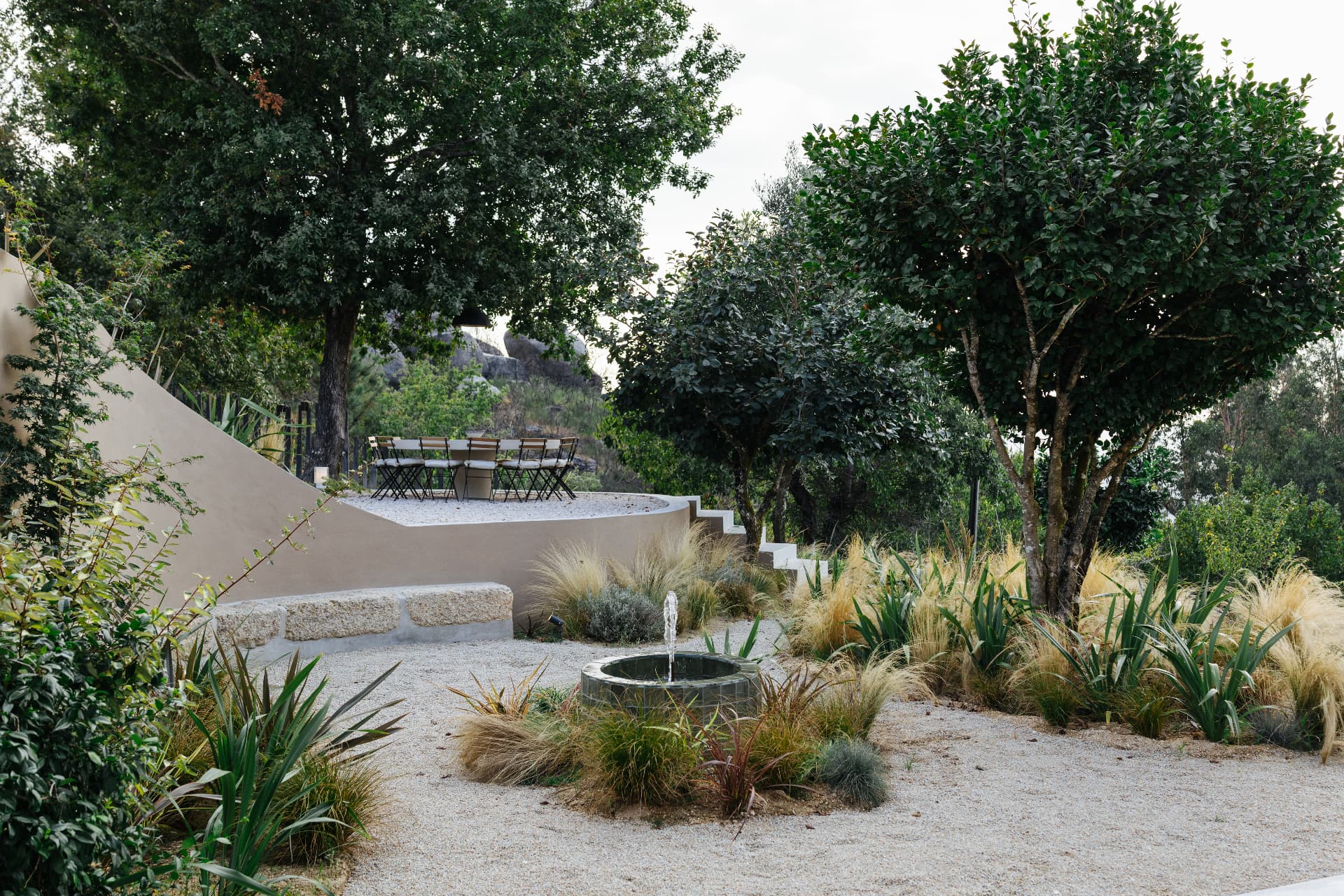 Gravel garden with water feature and outdoor dining terrace