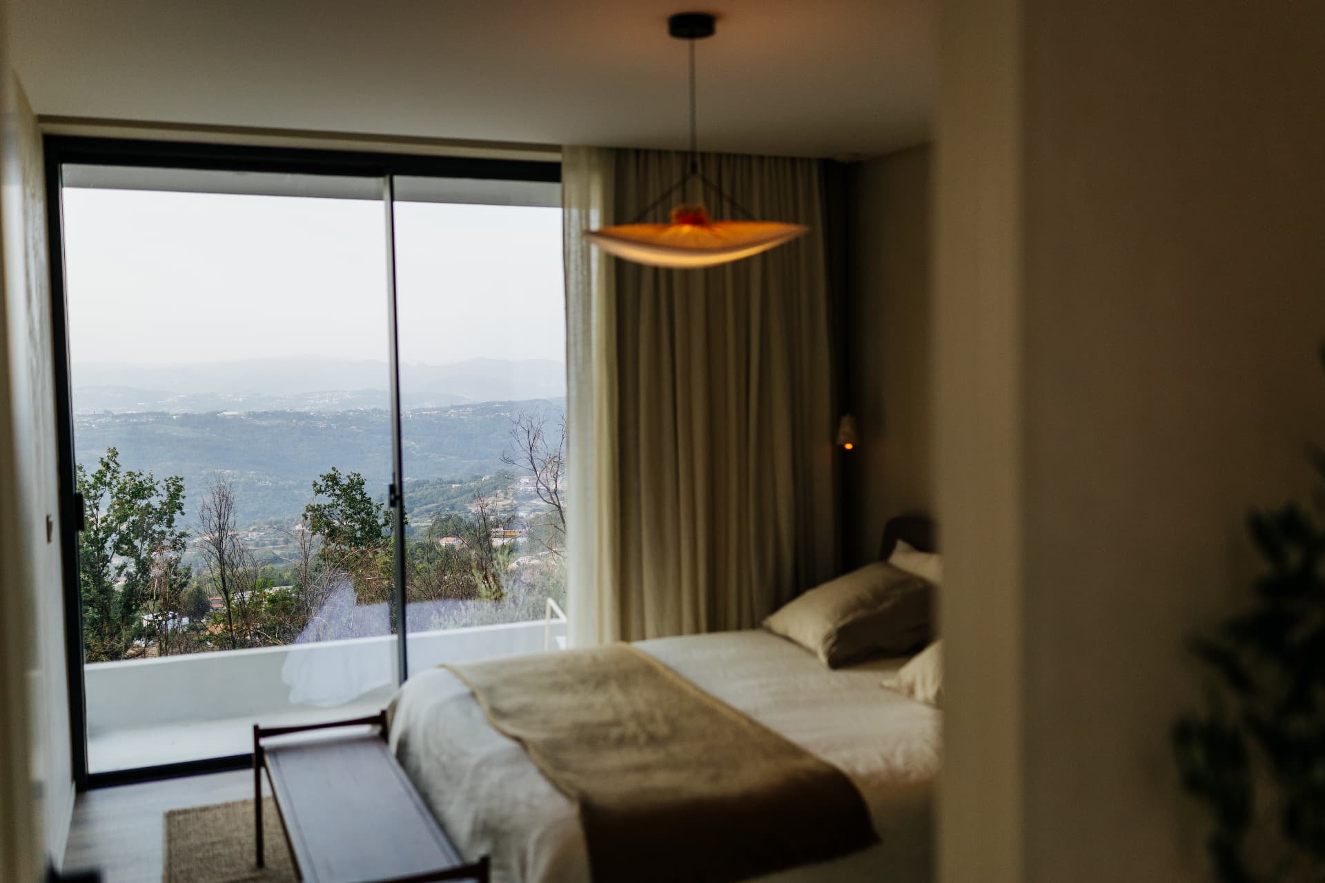 Bedroom opening onto a balcony with sweeping mountain views