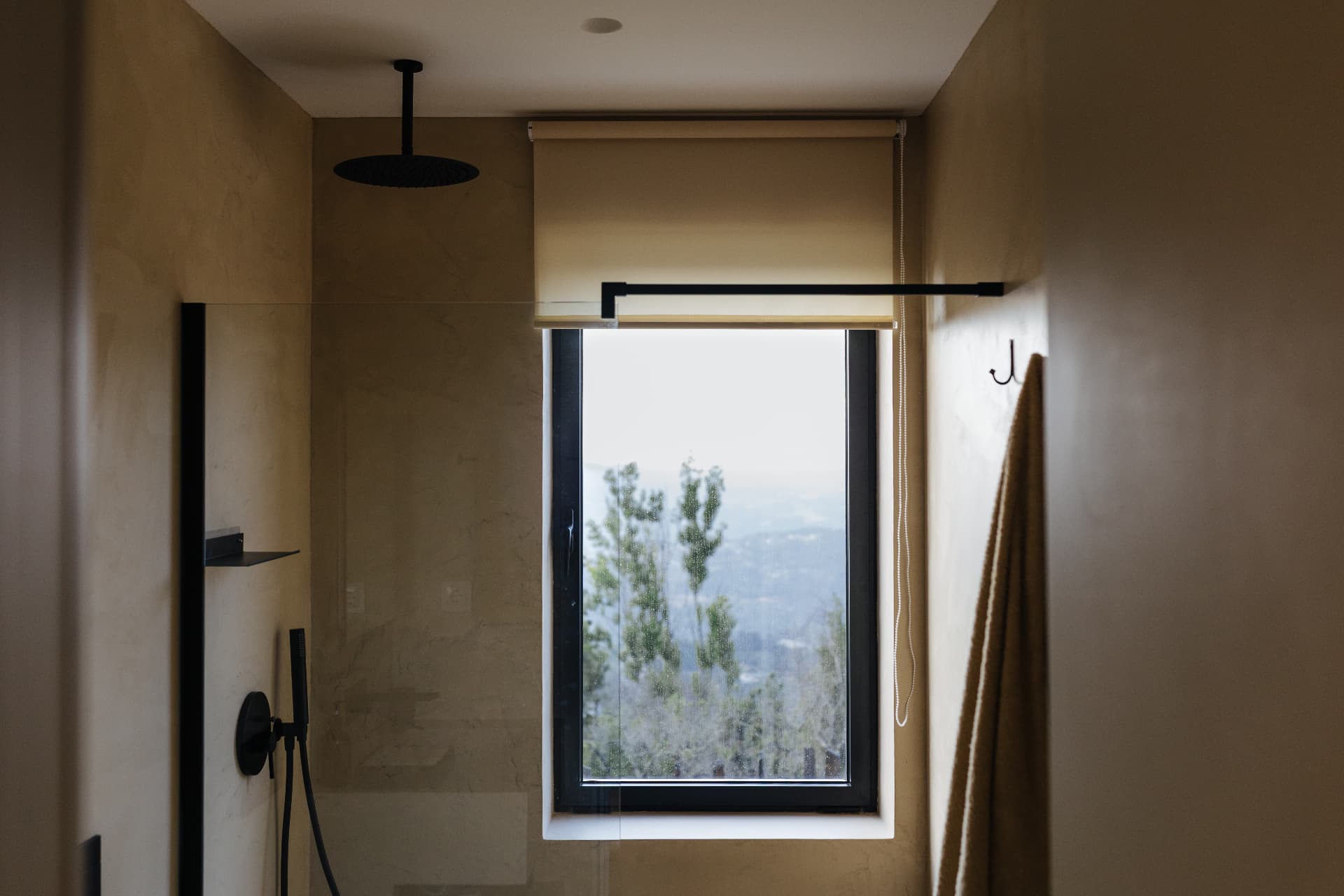 Bathroom with rainfall shower and valley view through the window