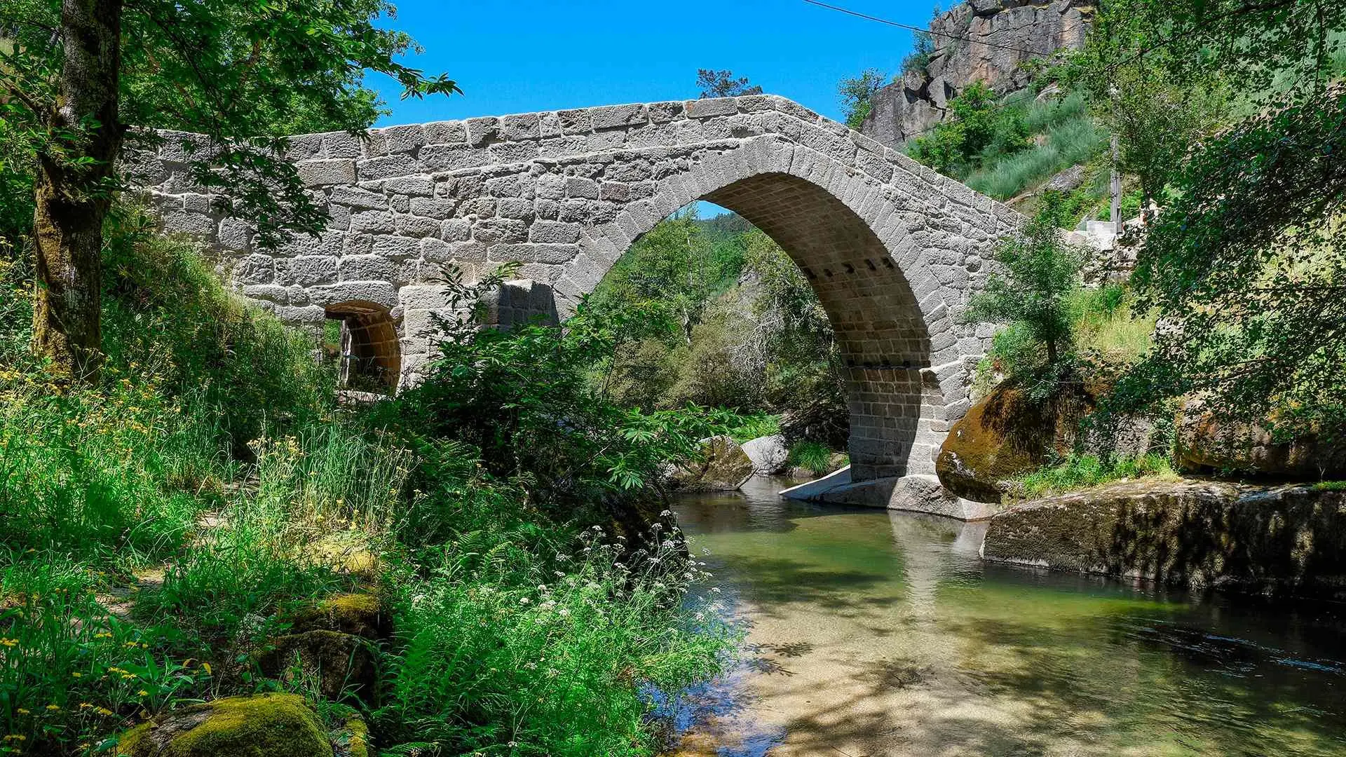Ponte do Arco, a historic Romanesque bridge over crystal-clear river water