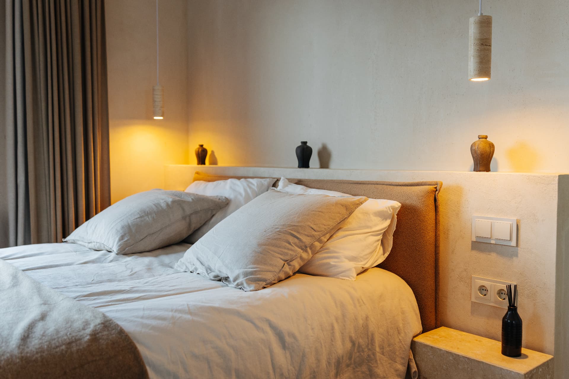 Double bedroom with pendant lights and a textured headboard wall