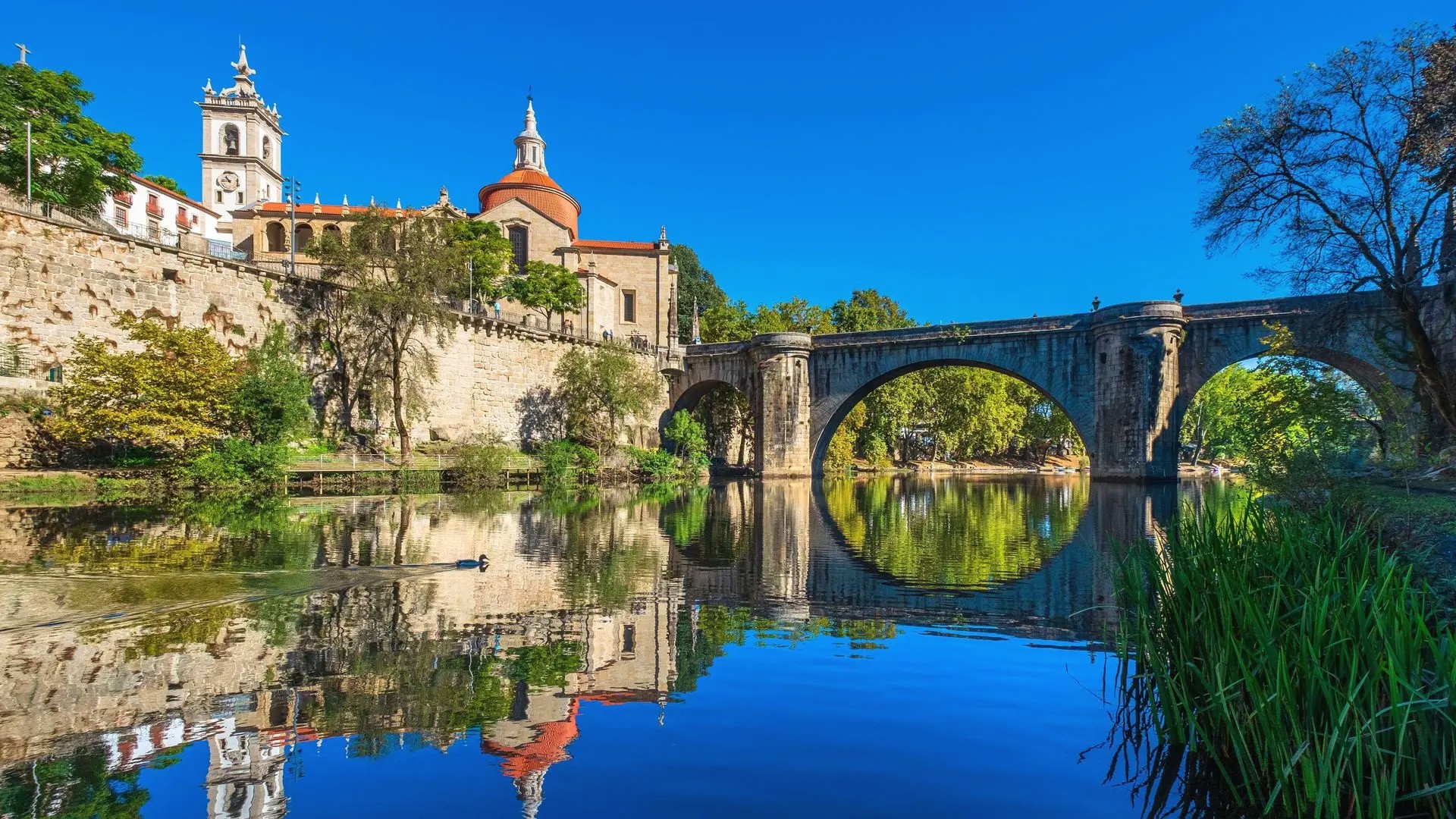 Historic bridge and church in Amarante reflected on the river